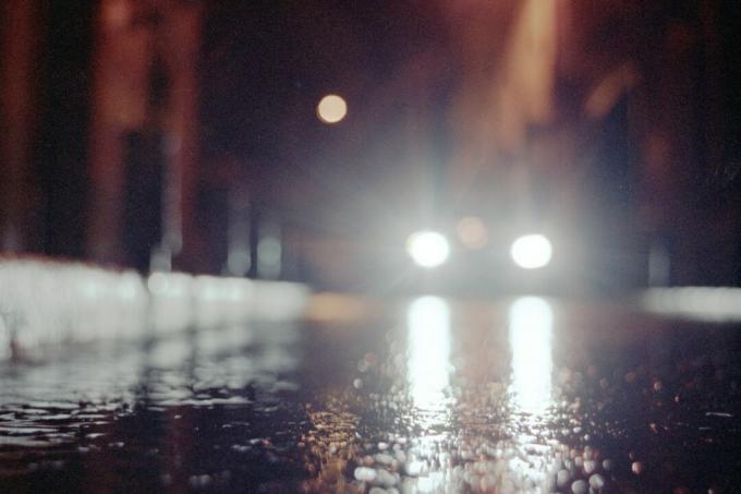 faróis de carro em noite chuvosa