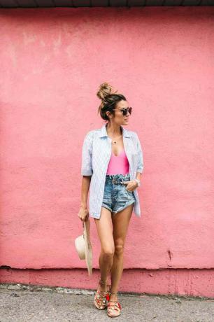 Moteris su džinsiniais šortais ir užsegamais marškiniais vasaros madai