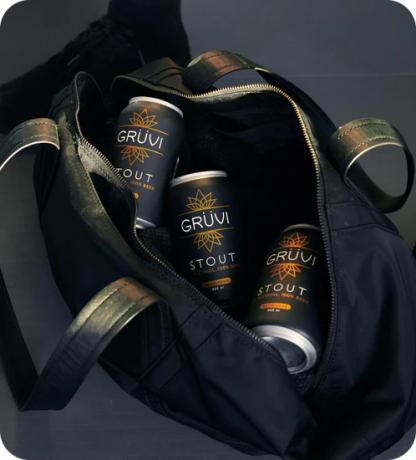 Sebuah tas terbuka untuk memperlihatkan tiga kaleng Grüvi di dalamnya.