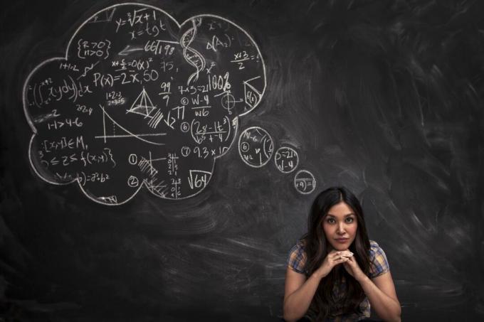 Chica contempla burbuja de pensamiento matemático en chalkboar