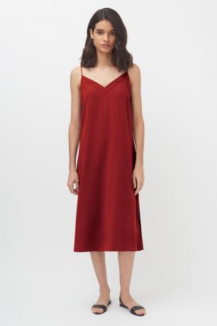 Bir model kırmızı spagetti askılı slip elbise giyiyor.