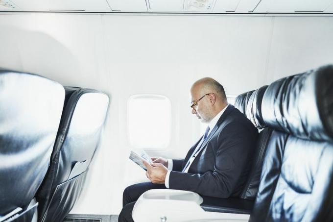 Hombre de negocios leyendo en vuelo