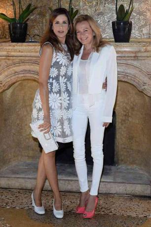 Caroline Scheufele (bersama Livia Firth), mengenakan sepatu koral cerah, dan skinny jeans putih.