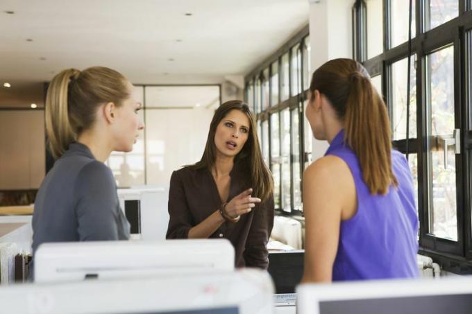 Tres mujeres en el cargo que tienen una discusión que está causando negatividad en su lugar de trabajo.