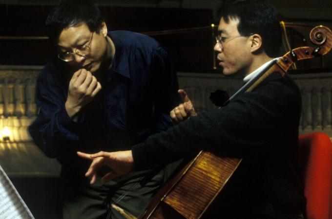 Yo-Yo Ma, laikantis violončelę, ir Bright Sheng žiūri į natas