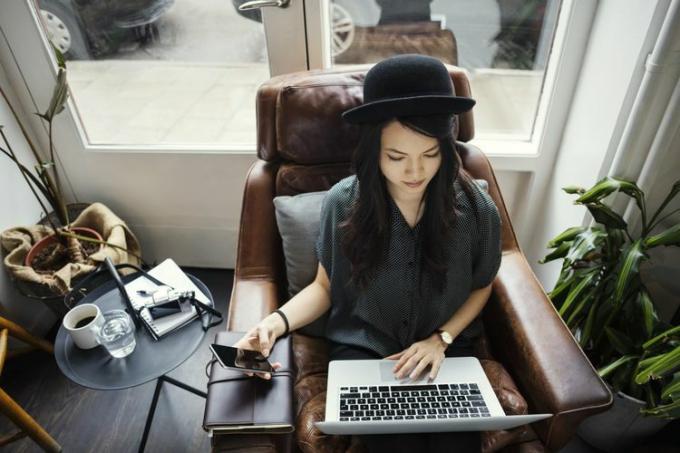 Wysoki kąt widzenia kreatywnej bizneswoman pracującej siedząc na krześle