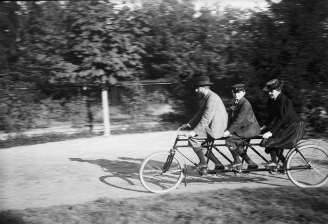 Grupo familiar em bicicleta tandem