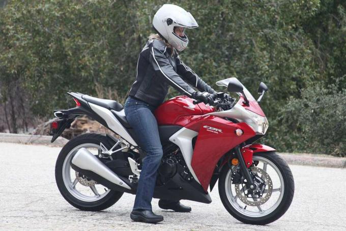 Kvinna som värmer upp en motorcykel