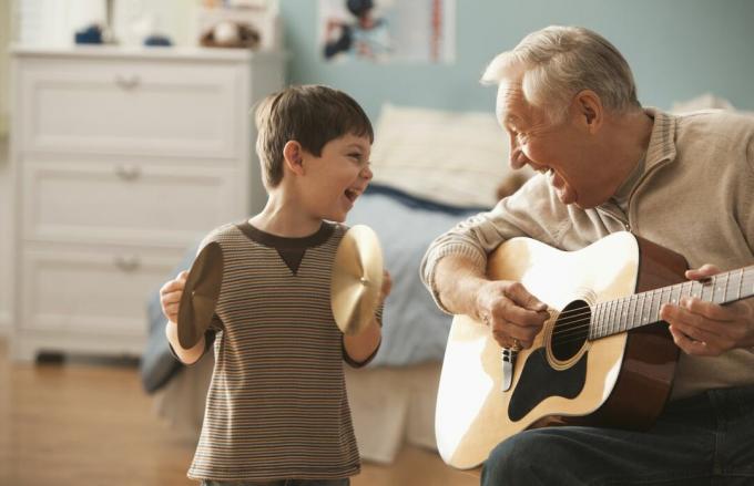 Großvater mit Junge, der Gitarre spielt