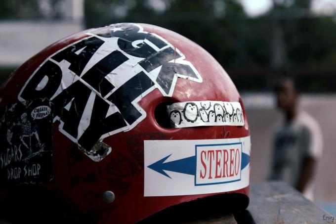 Zmlácená červená skateboardová helma pokrytá nálepkami