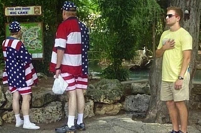 En mann som hedrer det amerikanske flagget, som bæres av to eldre mennesker