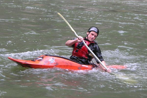 Un kayaker pagaia in una corrente in movimento