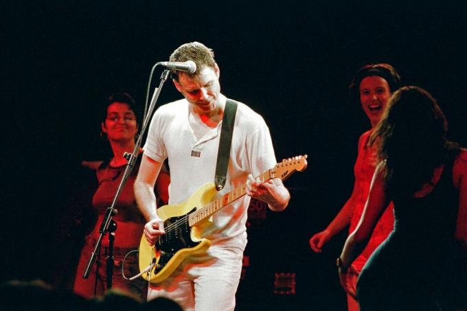 Stuart Adamson é acompanhado no palco por fãs de dança durante a apresentação de Big Country em 1994 em Kentish Town, Reino Unido.