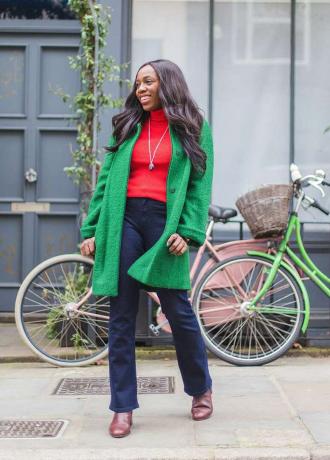 ブーツカットジーンズと緑のコートを着ている女性