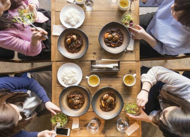 Pandangan tinggi terhadap empat wanita sedang makan.