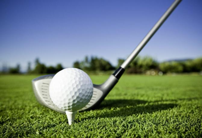 Golfo kamuolys ant trišakio ir golfo lazda golfo aikštyne