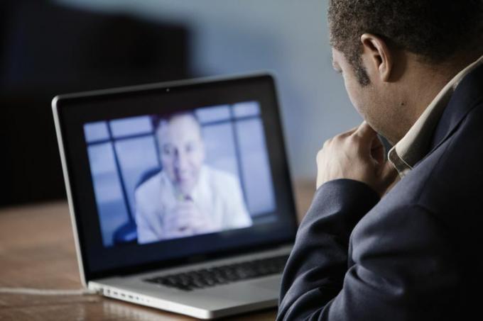 Hombres de negocios que tienen videoconferencia en la computadora portátil