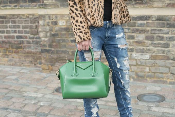 Foto street style di una donna in jeans strappati e cappotto leopardato