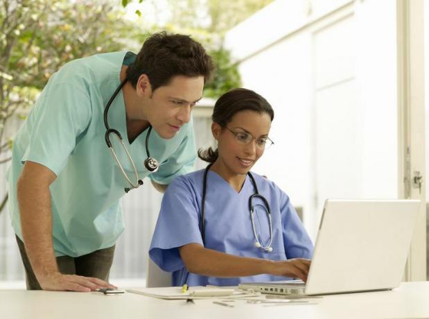 Dwóch lekarzy konsultuje się nad laptopem