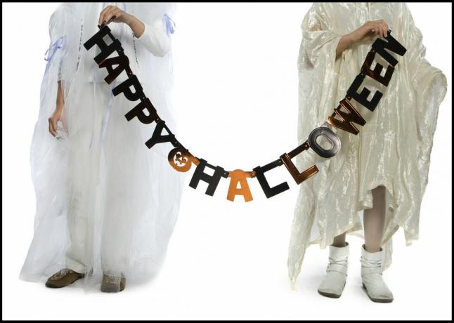Menino e uma menina segurando uma faixa de Halloween