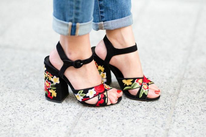 Ženské nohy v tmavých květinových sandálech