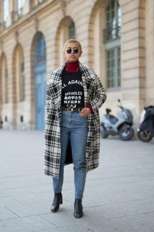 Street style mode kvinna i rutig kappa och jeans