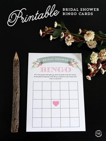 Una tarjeta de bingo de despedida de soltera con un lápiz de madera y flores.