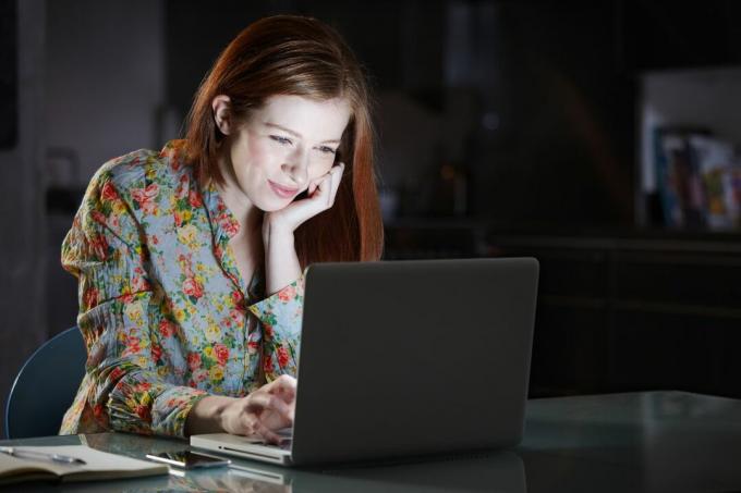 אישה משתמשת במחשב נייד בלילה