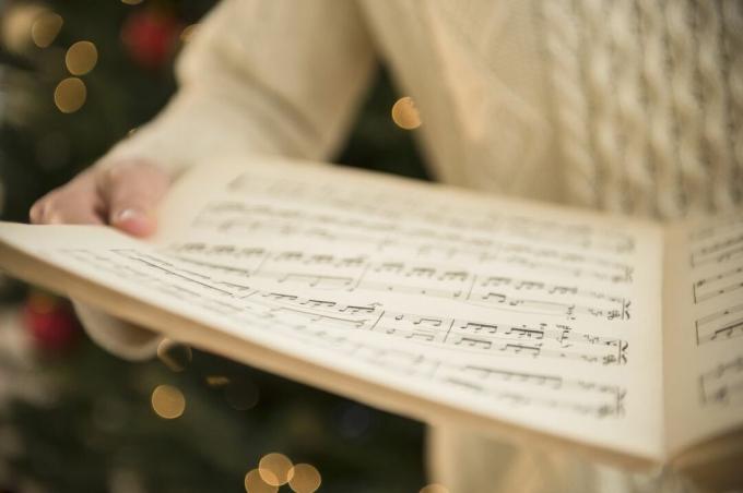 Een vrouw met bladmuziek voor Kerstmis.