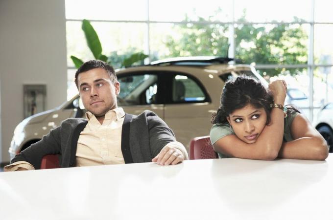 Frustriertes Paar sitzt im Autohaus
