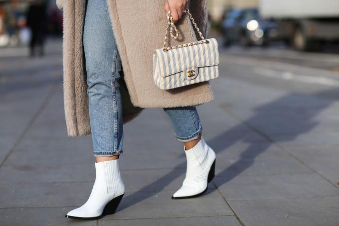 Piernas de mujer en jeans y botines blancos