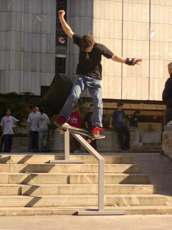 skateboardista klouzající po kolejích