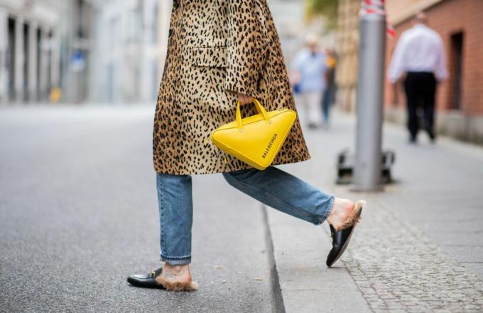 Vrouw in luipaardjas gele portemonnee en loafers met bont