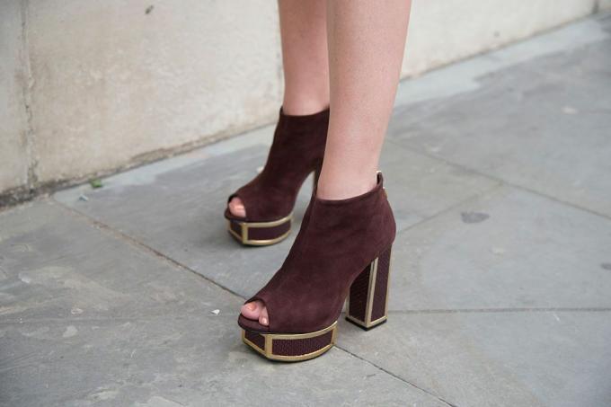 भूरे रंग के टखने के जूते में महिला के पैर