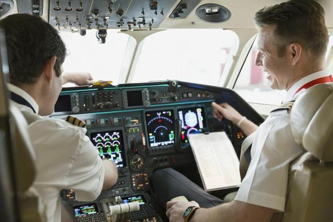 Pilot i drugi pilot sprawdzający instrumenty w kokpicie samolotu