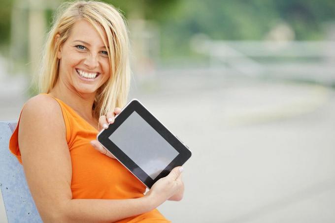 Imagen de una mujer sosteniendo felizmente una tableta