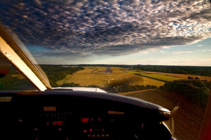 Vista desde la cabina de un avión que sobrevuela la campiña inglesa.