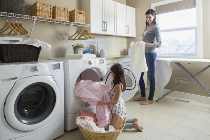 menina ajudando a mãe com a roupa lavada