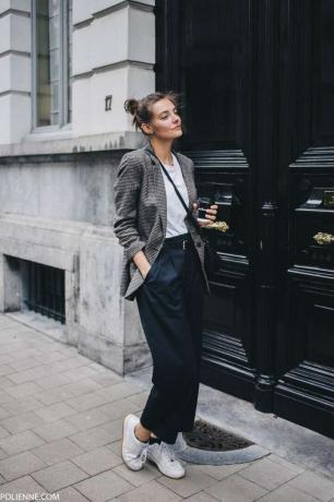Vrouw in broek en blazer op herenkleding geïnspireerde stijl