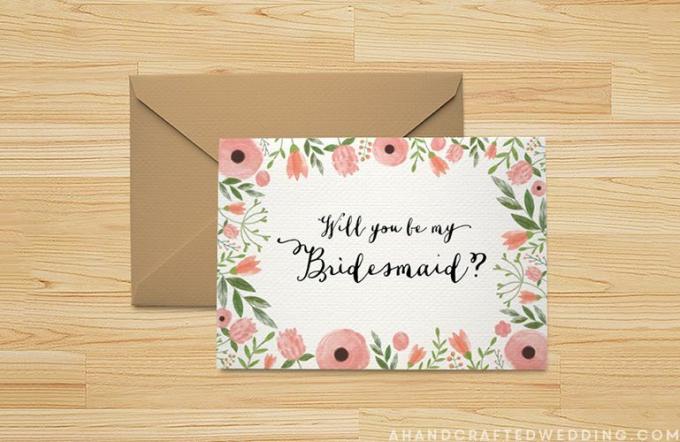 A Will You Be My Bridesmaid-Karte, die auf einen Tisch legt.