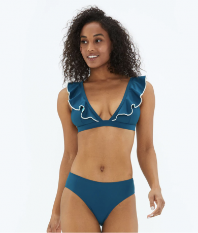 En modell i blå bikini med volangärmar.