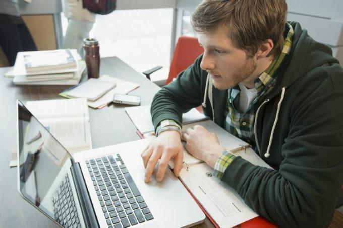 Un estudiante universitario que usa una computadora portátil para buscar oportunidades laborales.