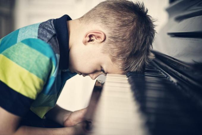 Niño deprimido frustrado con su lección de piano
