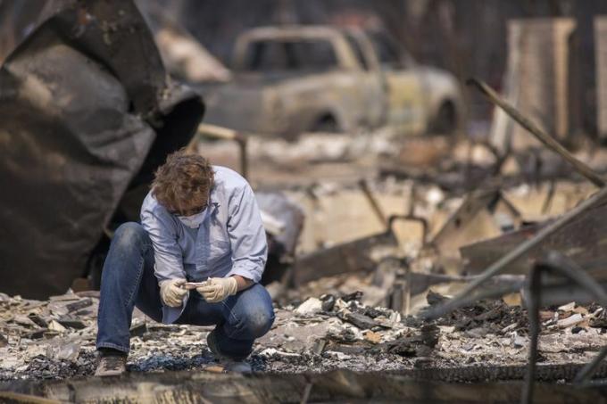 सोनोमा स्टेट यूनिवर्सिटी के स्वयंसेवी फोरेंसिक मानवविज्ञानी एलेक्सिस बाउटिन, पाई गई हड्डियों की जांच करते हैं 15 अक्टूबर, 2017 को सांता रोजा में आग से तबाह हुए घरों के बीच कैलिफ़ोर्निया नेशनल गार्ड्समैन द्वारा, कैलिफोर्निया.
