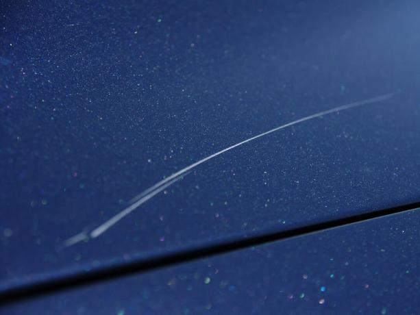 imagen de pintura rayada en el capó de un coche