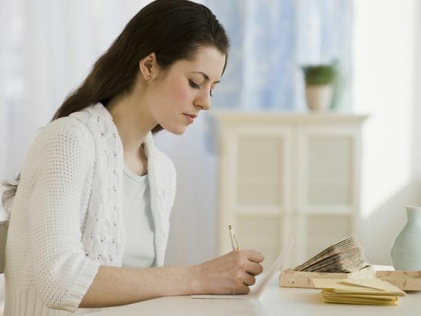 mujer escribiendo una nota manuscrita en el escritorio