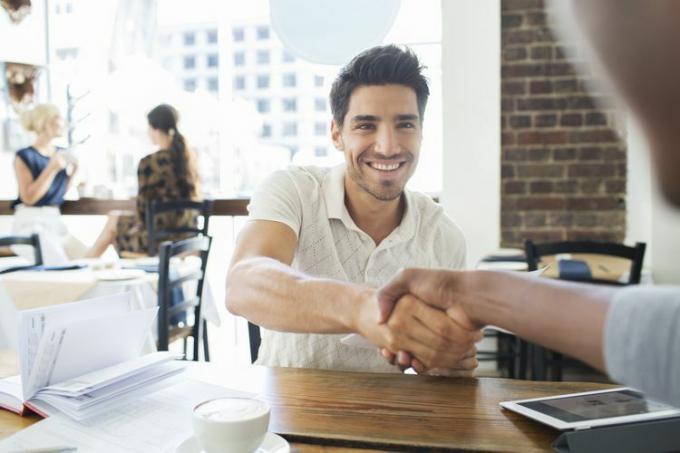 Los empresarios se dan la mano en el café.