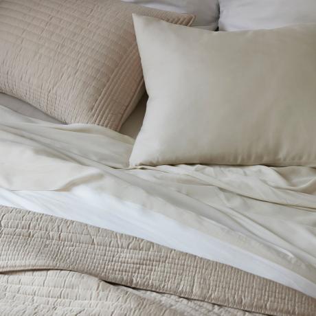 En säng gjord i neutrala Tencel-sängkläder.