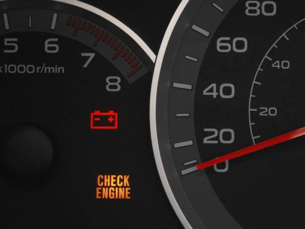 कार इंस्ट्रूमेंट क्लस्टर चेक इंजन लाइट और बैटरी लाइट दिखा रहा है, जिसका मतलब यह हो सकता है कि कार की बैटरी खत्म हो गई है
