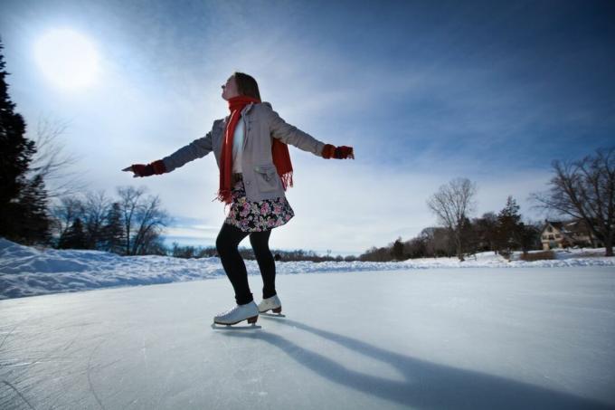 Tânără patinatoare pe gheață patinaj pe patinoar în aer liber